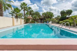 una piscina con agua azul y palmeras en Knights Inn Arcadia, en Arcadia