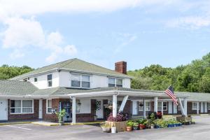 an image of a white house with an american flag at Elite Inn in Moosup