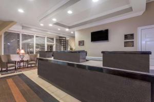 a lobby with a bar with chairs and a tv at Travelodge by Wyndham Lakeland in Lakeland