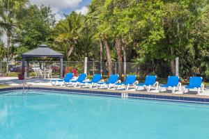 a pool with blue lounge chairs and a gazebo at Travelodge by Wyndham Lakeland in Lakeland +58 photos