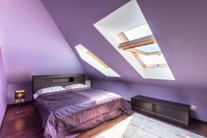 a bedroom with purple walls and a bed and skylights at Apartament Osiedle Bałtyk in Grzybowo