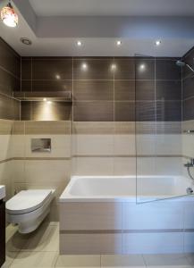 a bathroom with a bath tub and a toilet at Apartament Osiedle Bałtyk in Grzybowo