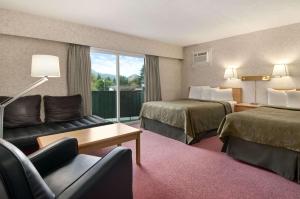 une chambre d'hôtel avec deux lits et un canapé dans l'établissement Travelodge by Wyndham Hope, à Hope