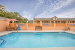 uma piscina em frente a uma casa em Super 8 by Wyndham Sumter em Sumter