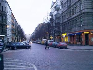 a person walking down a brick street in a city at Lette'm Sleep Berlin in Berlin
