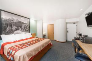 a hotel room with a bed and a flat screen tv at Super 8 by Wyndham Show Low in Show Low