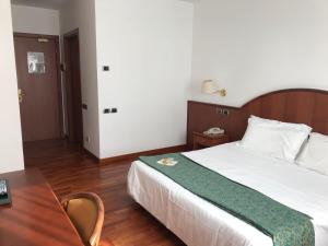 a hotel room with a bed and a table and a desk at Hotel In Sylvis in Sesto al Reghena