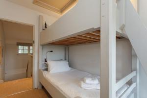 Plum Cottage - Vivre Retreats في ويمبورن مينستر: غرفة نوم مع سرير بطابقين مع ملاءات بيضاء