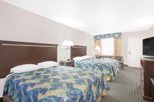 a hotel room with two beds and a flat screen tv at Super 8 by Wyndham Corpus Christi in Corpus Christi