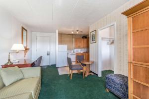een woonkamer en een keuken met een bank en een tafel bij MOOSEJAW INN in Moose Jaw
