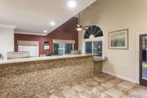 a large kitchen with a bar with a ceiling fan at Travelodge by Wyndham Hemet CA in Hemet