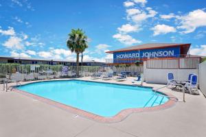 a large swimming pool with chairs and a building at Howard Johnson by Wyndham Las Vegas near the Strip in Las Vegas