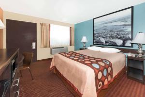 a hotel room with a bed and a television at Super 8 by Wyndham Midwest City OK in Midwest City
