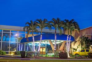 a large palm tree in front of a large building at Knights Inn Hallandale in Hollywood