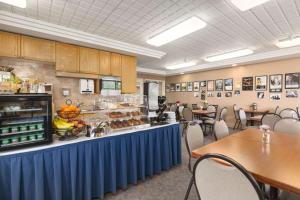 a cafeteria with tables and a counter with food at Travelodge by Wyndham Spruce Grove in Spruce Grove
