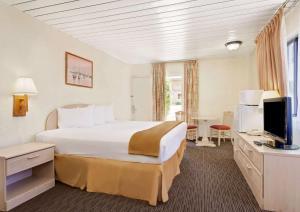 a hotel room with a large bed and a television at Knights Inn Page in Page