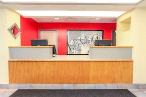 a lobby with red walls and a reception desk at Super 8 by Wyndham Sault Ste. Marie in Sault Ste. Marie