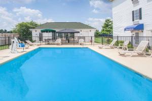 a swimming pool with chairs and a house at Howard Johnson by Wyndham Jackson in Jackson