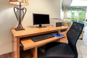 a desk with a computer monitor and a keyboard at Super 8 by Wyndham Sault Ste. Marie in Sault Ste. Marie