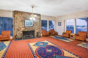 a living room with a stone fireplace and chairs at Travelodge by Wyndham Laramie in Laramie