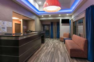 a hotel lobby with a bar and two chairs at Super 8 by Wyndham San Antonio Near Fort Sam Houston in San Antonio