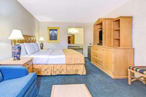 a hotel room with a bed and a couch at Knights Inn Kissimmee in Kissimmee +40 photos