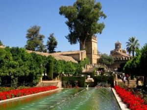 een fontein in een tuin met rode bloemen bij Tendillas Suite in Córdoba