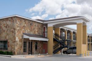 a large brick building with a staircase in front at Super 8 by Wyndham San Antonio Near Fort Sam Houston in San Antonio