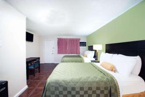 Postel nebo postele na pokoji v ubytování Executive Inn & Kitchenette Suites-Eagle Pass