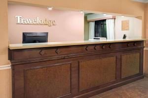 a hotel lobby with a reception desk with a television at Travelodge by Wyndham Beckley in Beckley