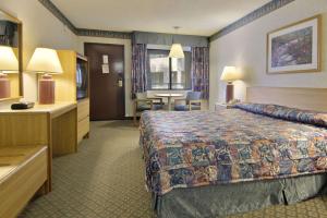 a hotel room with a bed and a table at Travelodge by Wyndham Commerce Los Angeles Area in Commerce