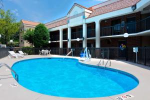 a large swimming pool in front of a building at Super 8 by Wyndham Huntersville/Charlotte Area in Huntersville