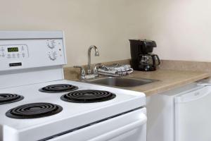 a kitchen with a white stove and a sink at Super 8 by Wyndham Kingston in Kingston