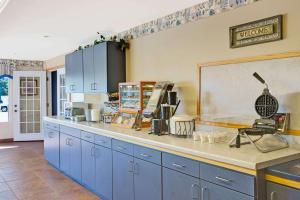 a kitchen with blue cabinets and a counter top at Travelodge by Wyndham Rapid City in Rapid City