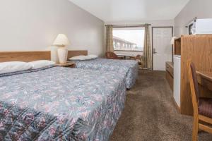 a hotel room with two beds and a table at Knights Inn Boardman in Boardman