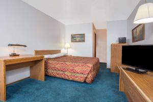 a hotel room with a bed and a flat screen tv at Knights Inn Boardman in Boardman