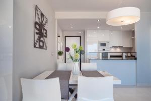 アレナレス・デル・ソルにあるGorgeous Infinity View Apartmentのキッチン、ダイニングルーム(テーブル、椅子付)