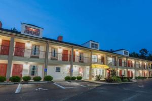 a large white building with a parking lot at Super 8 by Wyndham Alexander City in Alexander City