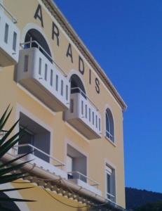 a yellow building with a sign on the side of it at Hôtel Paradis in Bormes-les-Mimosas