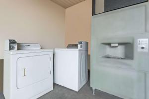 uma lavandaria com um frigorífico e uma máquina de lavar e secar roupa em Knights Inn Greenville em Greenville