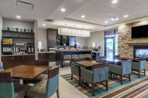 a restaurant with tables and chairs and a bar at Hawthorn Suites by Wyndham Wheeling at The Highlands in Triadelphia