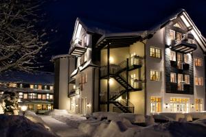 ein Gebäude im Schnee in der Nacht in der Unterkunft Land- und Kurhotel Tommes in Schmallenberg