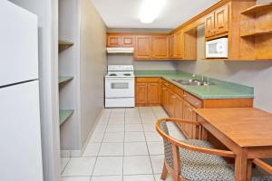 a kitchen with wooden cabinets and a table and a stove at Super 8 by Wyndham South Bend in South Bend +6 photos