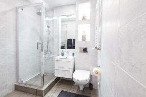 ジェシュフにあるMW apartmentsの白いバスルーム(シャワー、トイレ付)