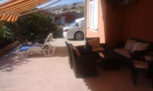 a patio with chairs and a car parked in a driveway at Apartments Jela in Metajna