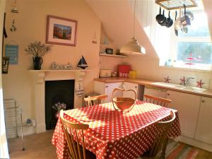uma cozinha com uma mesa com uma toalha de mesa de bolinhas vermelhas e brancas em Happy Seaside Days in Combe Martin, Devon em Combe Martin