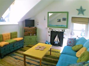 a living room with a blue couch and a fireplace at Happy Seaside Days in Combe Martin, Devon in Combe Martin