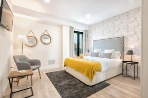 Habitación de hotel con cama y silla en iloftmalaga Carretería - Rosaleda, en Málaga