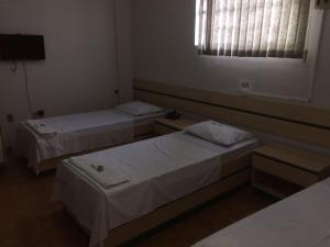 a hotel room with two beds and a window at Hotel Real in Petrolina