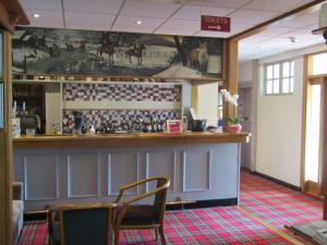 a bar in a restaurant with a picture on the wall at Hunters Lodge Hotel in Gretna Green